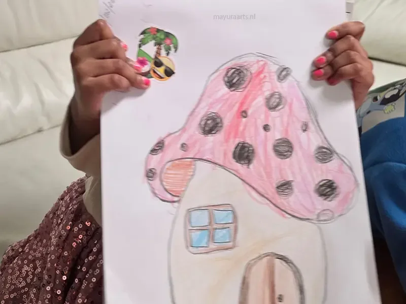 A student displaying their drawing of a whimsical pink spotted mushroom house.
