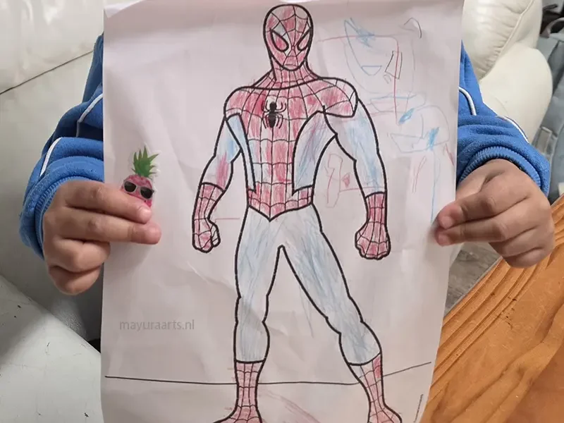 A young artist proudly holding up their completed Spider-Man coloring project.